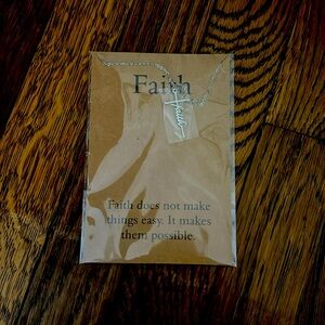 A silver cross necklace with the word faith spelled out on the cross!